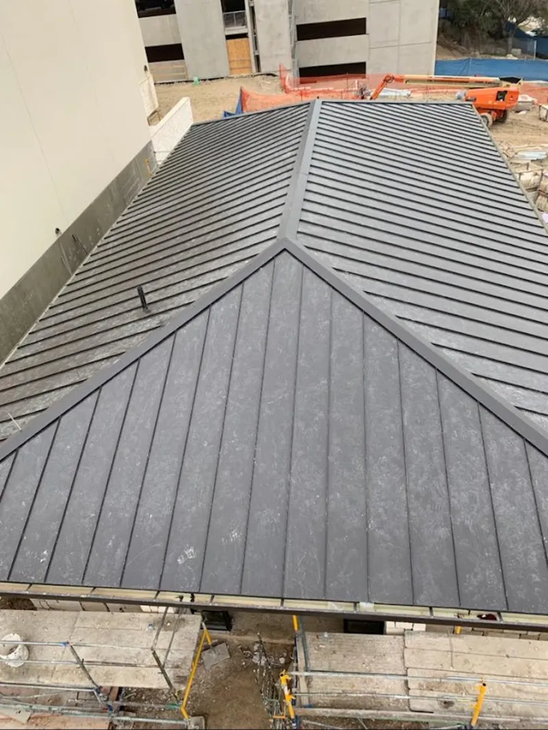 Commercial metal roof construction with crane equipment in White Lake