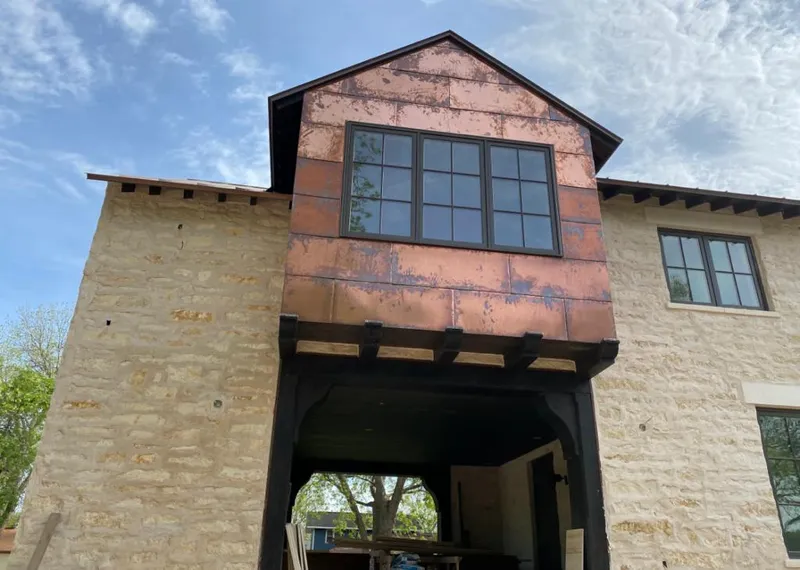 Copper metal panel facade on a stone building for Skylight Installation in White Lake